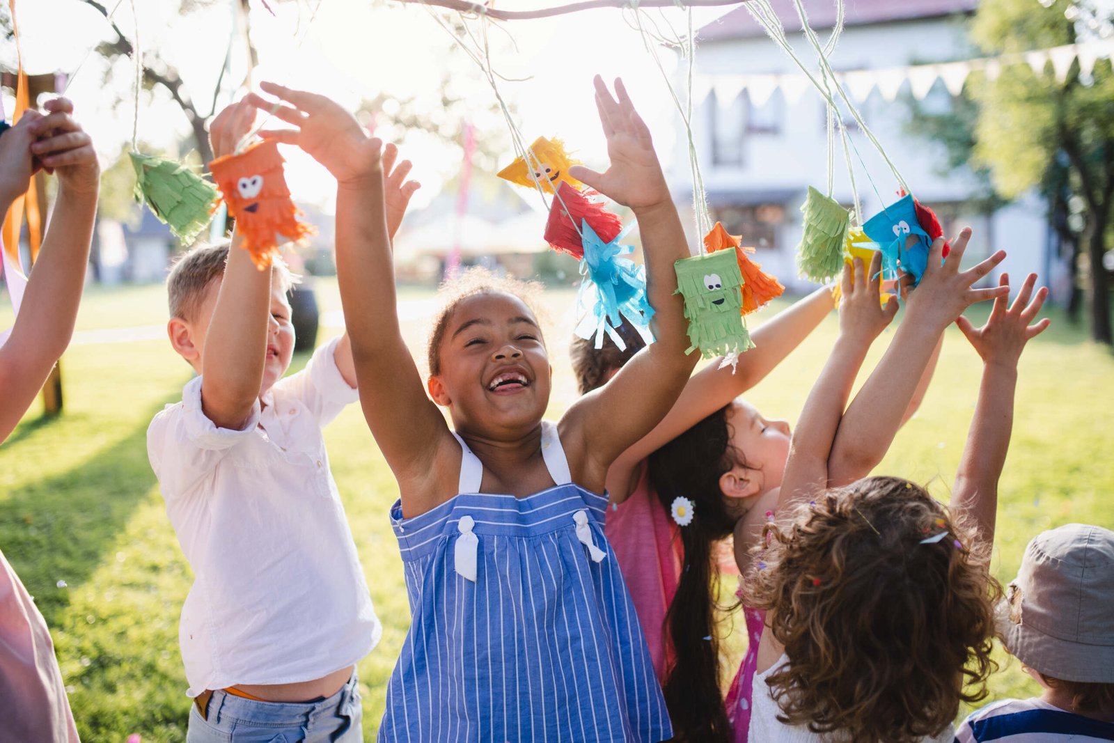 Small children standing outdoors in garden in summer, playing. A celebration concept.